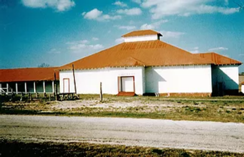 A large white building with brown roof and sky background