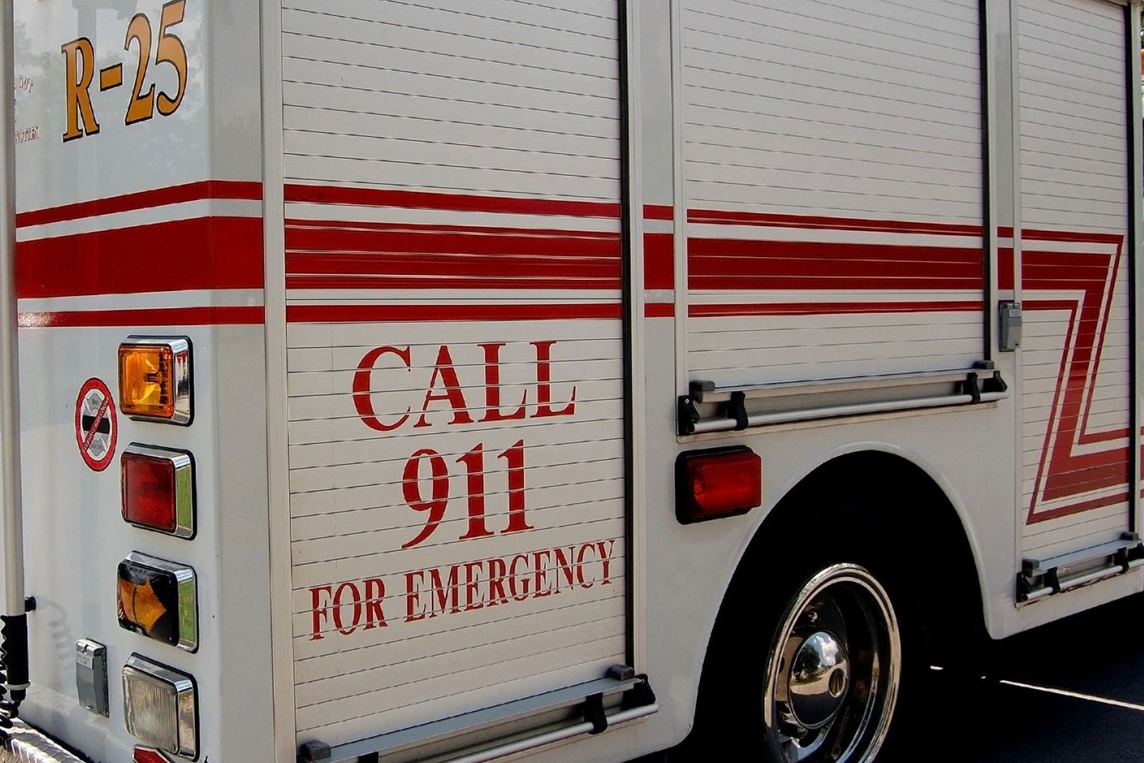 A fire truck with the words " call 9 1 1 for emergency ".